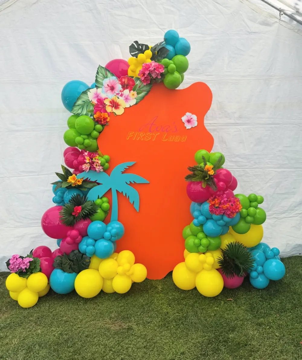 Tropical first luau birthday balloon arch with florals and palm tree